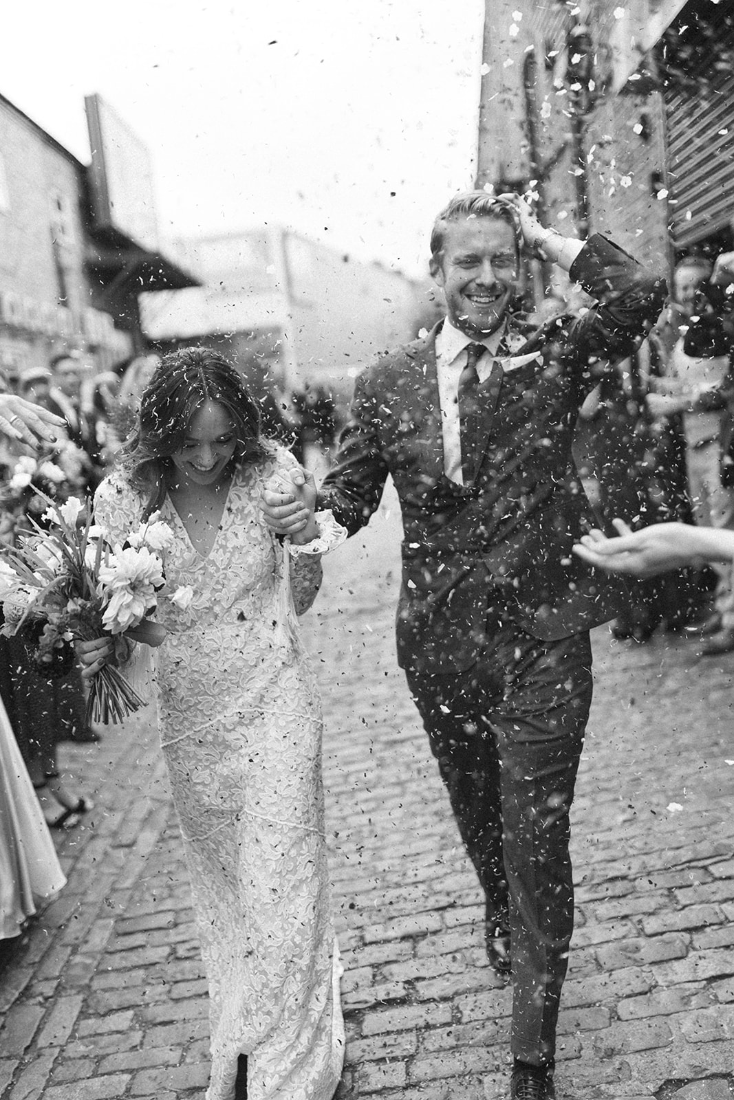 bride and groom walk through confetti outside fitzrovia chapel london wedding